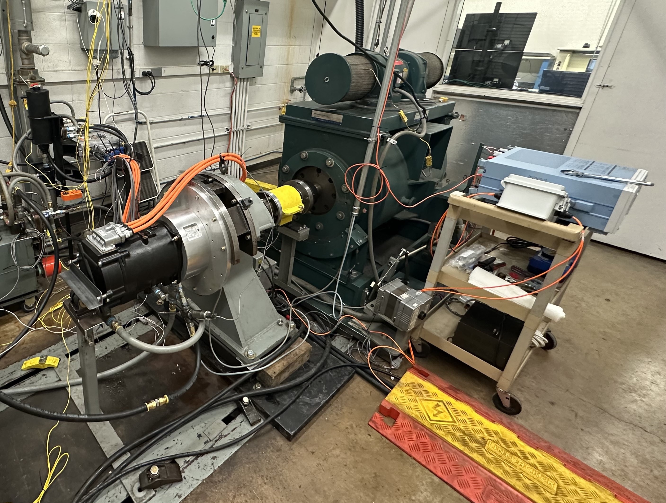 Figure 1: The test motor and inverter mounted on the component dynamometer. The power analyzer is also visible.