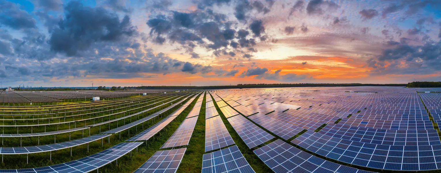 solar power station against a cloud-filled sky at sunset