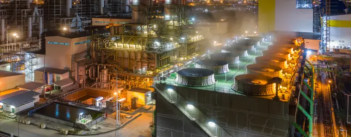 Aerial view of combined cycle power plant and cooling tower during operation with steam or plume