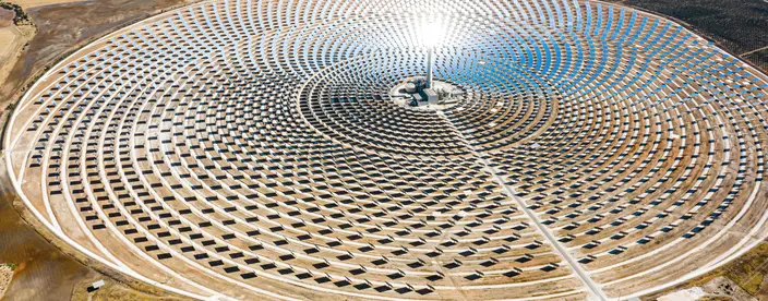 Solar panels in a large thermal circular power plant with the reflection of the sunlight in the panels