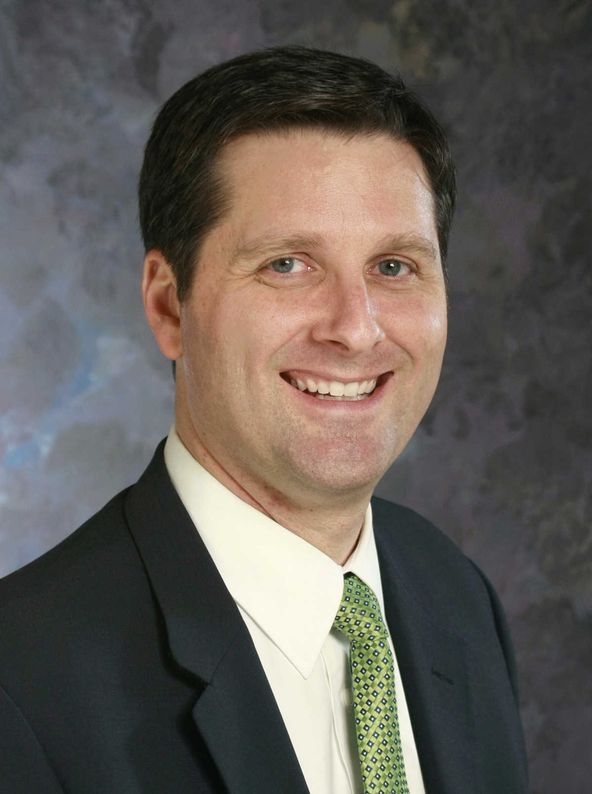 Portrait of Paul Evans against a grey background