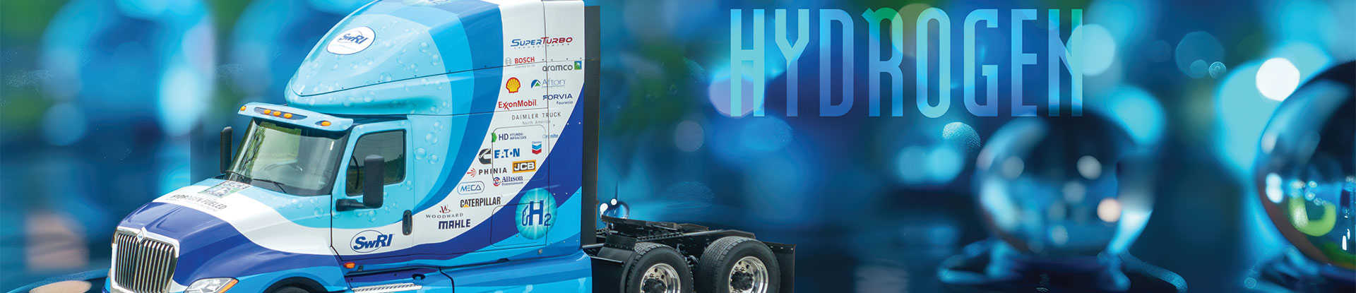 H2-ICE heavy-duty tractor-trailer on a blue background. A semi-transparent text in the background says 'Hydrogen'. 