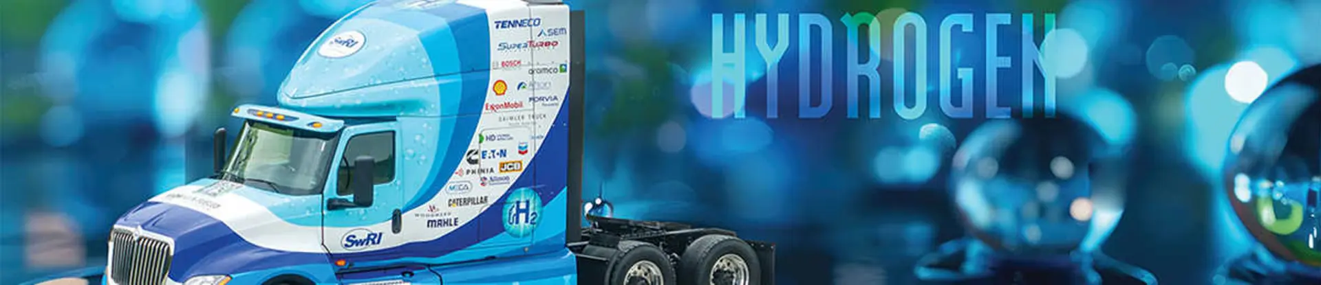 H2-ICE heavy-duty tractor-trailer on a blue background. A semi-transparent text in the background says 'Hydrogen'. 