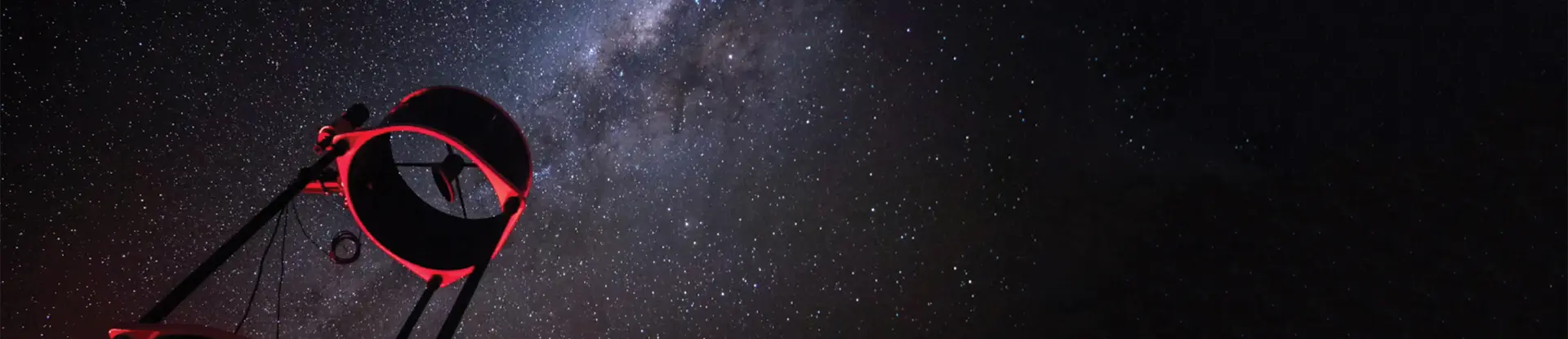 Telescope against starry night sky