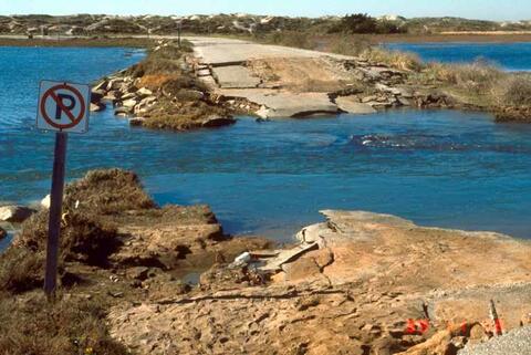 Destroyed cement causeway with water overflowing the road in Watsonville, California