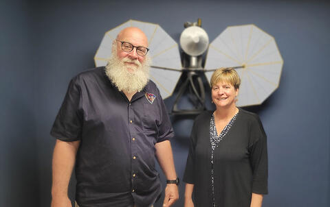 Portrait of Dr. Hal Levison and Dr. Cathy Olkin in front of a Lucy display