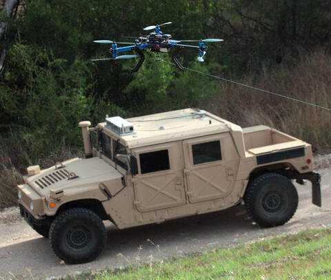 Unmanned ground vehicle driving with a drone flying overhead